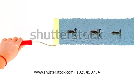 person painting tree gooses swimming on a lake on a white wall with a roller brush