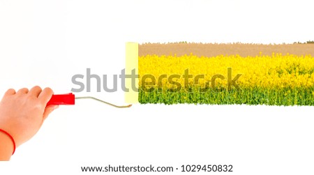 Person painting a landscape with yellow flowers on a white wall with a roller brush