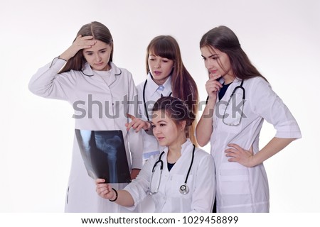 4 smiling nurses in white medical robes with medical utensils