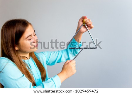 Girl plays a triangle