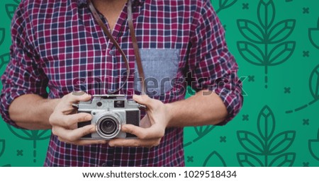 Digital composite of Man mid section with camera against green nature pattern