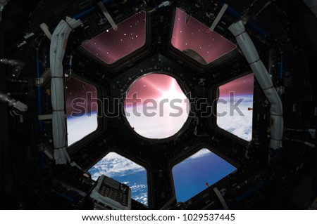 Earth in window of spaceship. Elements of this image furnished by NASA.
