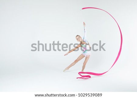 Rhythmic gymnastics caucasian blonde girl in sportswear dress showing flexibility and acrobat balance on white background isolated