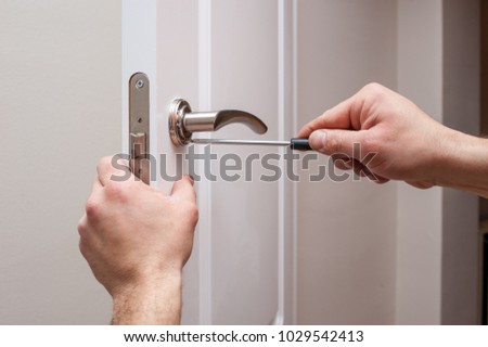 man screwing with a screwdriver at home Royalty-Free Stock Photo #1029542413