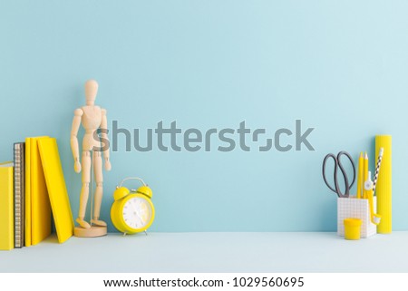 Student creative desk mock up with yellow supplies, mannequin and blue wall. Back to school. Royalty-Free Stock Photo #1029560695