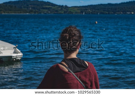 rear view of woman watching towards horizon on lake