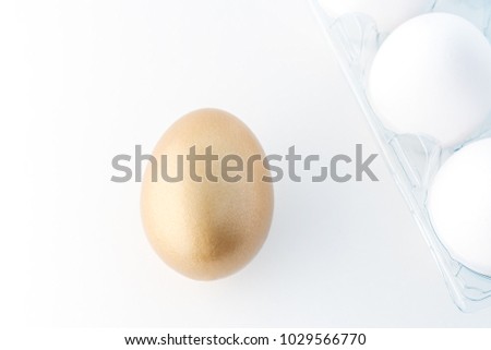 One gold egg and white eggs on white background