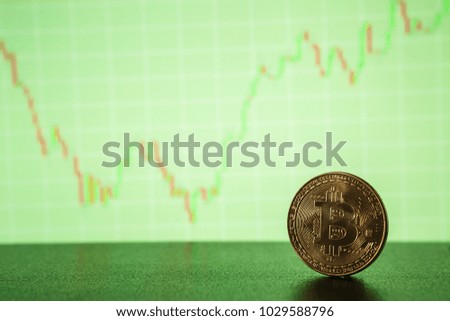 Bitcoin gold coin on the background of the graph of the monitor. Business concept