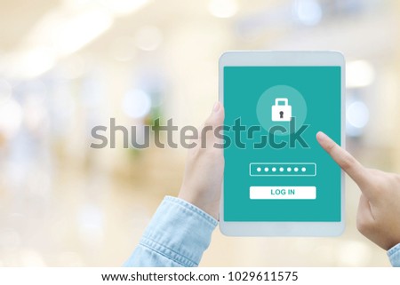 Hand using tablet with password login on screen, cyber security concept