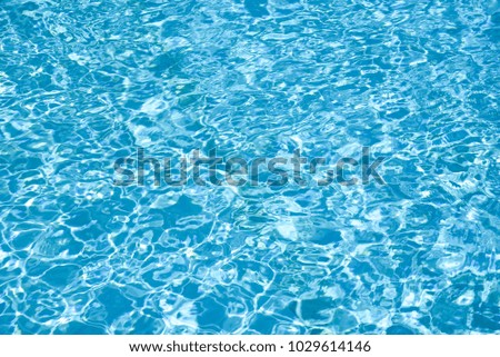 Ripple water in swimming pool with sun reflection