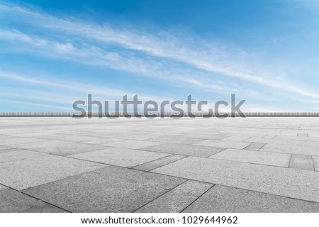 Asphalt pavements and square floor tiles under the blue sky and white clouds Royalty-Free Stock Photo #1029644962
