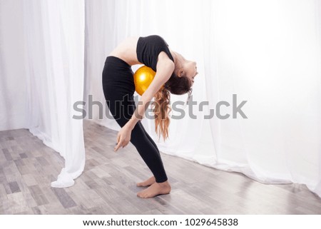 Gymnast with a ball exercising. Flexibility in the back