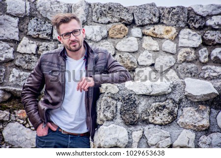 Handsome hipster guy portrait. textured stone background