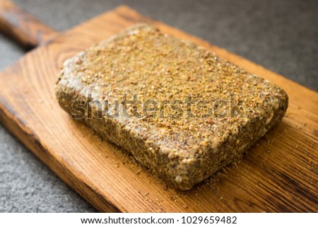 Raw vegan bread on wooden board. Made with soaked green buckwheat, wheat sunflower seeds, flax seeds, pumpkin seeds, cashew, walnuts. Spices and herbs used. No backing. Vegetarian healthy food concept