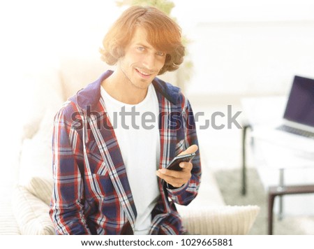 modern guy with a smartphone on a blurry background.