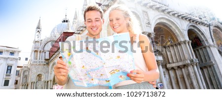 Travel banner, couple reading map in Venice, Italy on Piazza San Marco by Saint Mark's Basilica. Happy young couple on travel vacation in Europe. Happy woman and man in love traveling together.