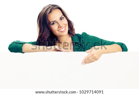 Happy smiling young woman in green casual clothing, showing blank signboard or copyspace for advertise, slogan or text, isolated against white background