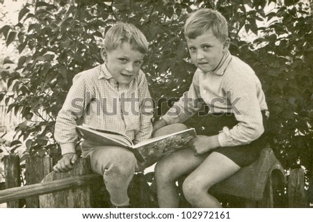 Vintage photo of brothers reading a book (sixties)