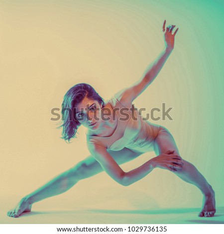 Modern teen contemporary dancer poses in front of the studio background. Toned image. Like a doll view. Square cropping