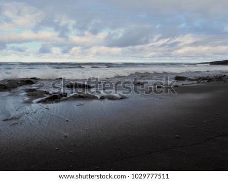 Punalu'u Black Sand Beach with Shining Wet Sand, Distant Calm Waves, Rocks, and Cloudy Sky, The Big Island, Hawaii