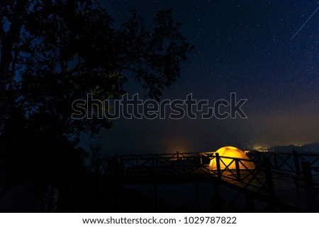 Lonely camping on the mountain under the stars and blue sky.