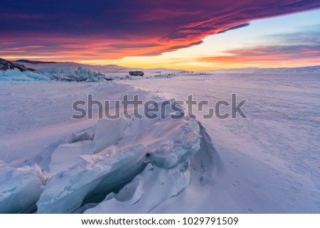 Winter landscape in sunset, Cracked frozen lake covered of snow at lake Baikal, Russia in sunset