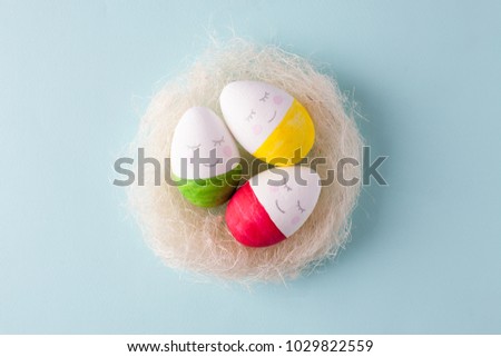 group of funny colorful eggs in the nest - a concept of merry Easter, funny characters, emotions.

