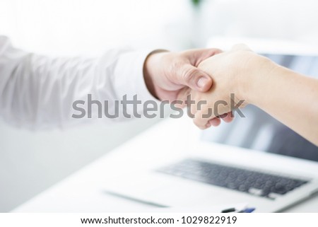 Male doctor helps adult patient. Holding her hand.