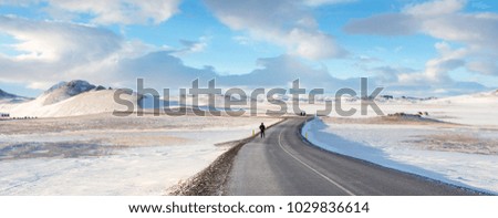 Travellers walking on the road in Krafla Vito geothermal area, Iceland