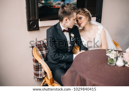 bride and groom sitting in a cafe on the summer terrace
