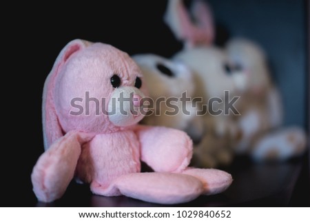 Pink teddy bears on a stick with white bunnies
