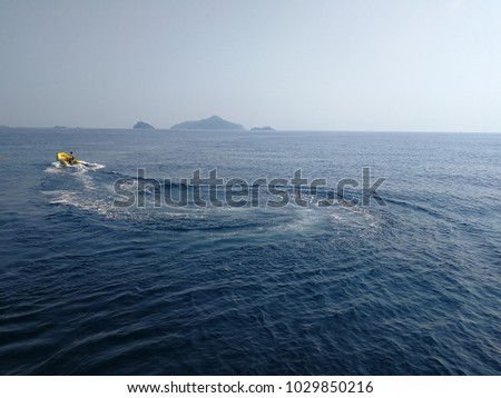 Men ride the yellow rubber boat in the big sea.and white clound background.