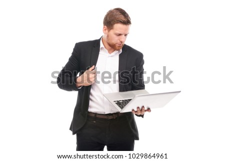 Studio portrait of young manager in suit holding laptop on white background