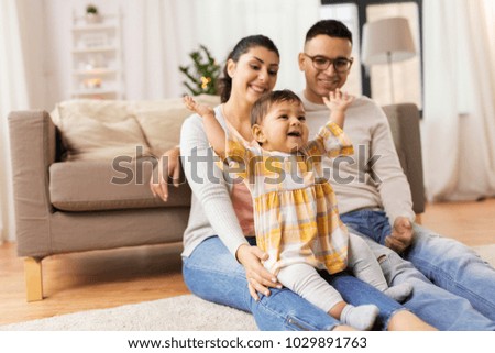 family, parenthood and people concept - happy mother, father and baby daughter playing at home Royalty-Free Stock Photo #1029891763
