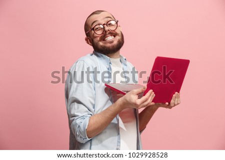 Businessman hugging laptop. Love to computer concept. Attractive male half-length front portrait, trendy pink studio backgroud. Young emotional bearded man. Human emotions, facial expression concept. Royalty-Free Stock Photo #1029928528
