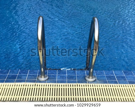 Blue swimming pool and stainless stair into the pool