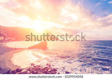 Beautiful seascape. People on the beach and sunset over the sea