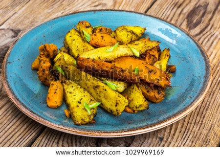 Baked vegetables, potatoes and pumpkin with herbs and spices. Studio Photo