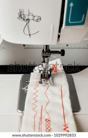 photo of a sewing machine close-up. Sewing machine stitching light fabric close-up. Detail photo of shuttle of needle working process. Garment industry, seamstress workplace, tailor workshop concept