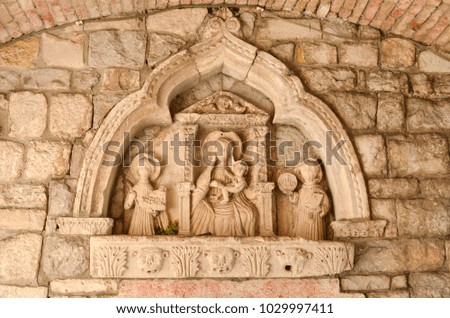 icon carved from stone on the wall