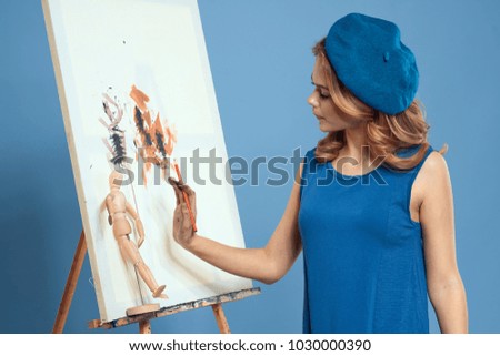 woman with a gestal paint on a canvas on a blue background                              