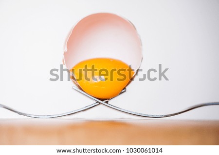 broken eggs in the shell on forks
