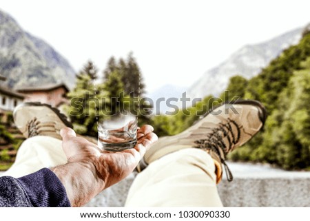 Man hand with free space for your decoration of product. Blurred legs with brown shoes and blurred landscape of spring time. Background for your decoration in hand. 