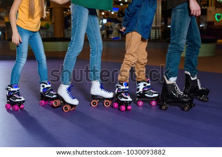 partial view of parents and kids skating on roller rink together Royalty-Free Stock Photo #1030093882