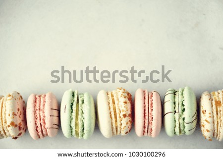 Colorful french macaroons flat lay. Pastel colors pink, green, yellow macarons with copy space, top view. Holidays and celebrations concept. Sweet gift for woman, girl.