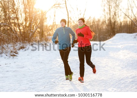 Photo of two athletes on morning run in winter park