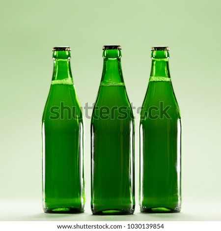Three green bottles on a light green background. Craft beers. St Patrick's Day. Irish culture.