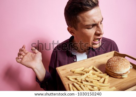   man with a tray on a pink background, fast food                             