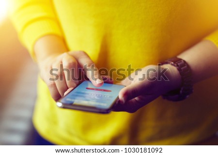 Woman signs up to banking with her mobile phone in the office
