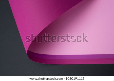 roll of purple and pink paper isolated on black